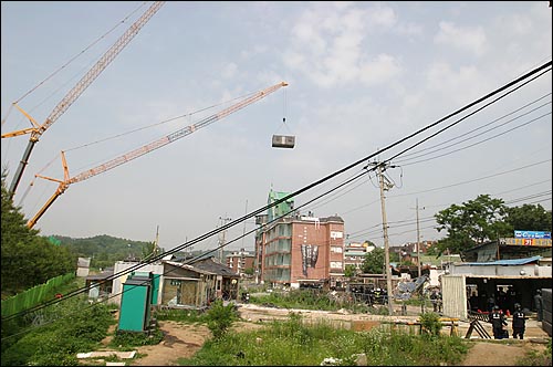 경찰이 대형 크레인을 이용해 W빌라쪽으로 컨테이너 박스를 이동시키고 있다. 